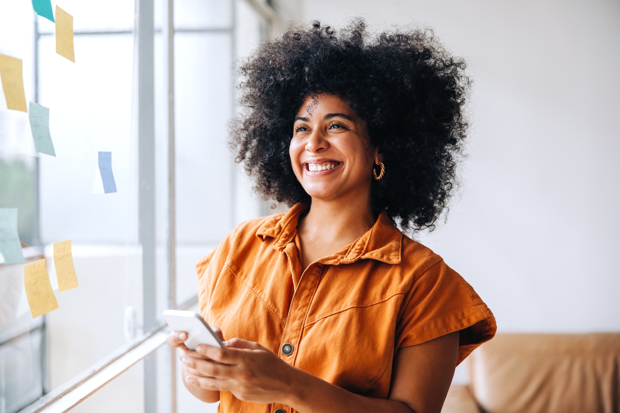 Woman smiling while using her phone, discovering wellness insights